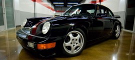 une porsche 2.7 RS Touring noire dans un hangar