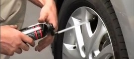 utilisation d'une bombe anticrevaison sur le pneu d'une auto