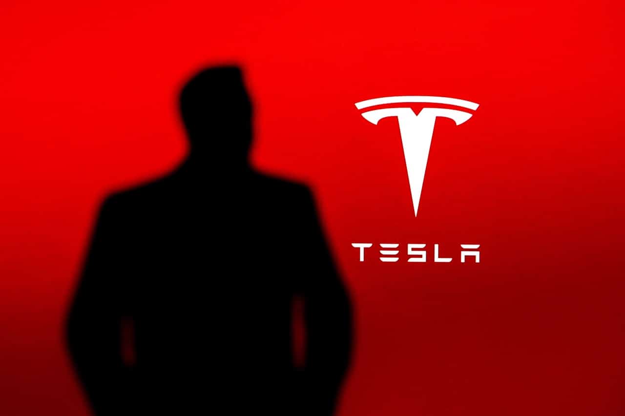 Elon Musk devant le logo Tesla